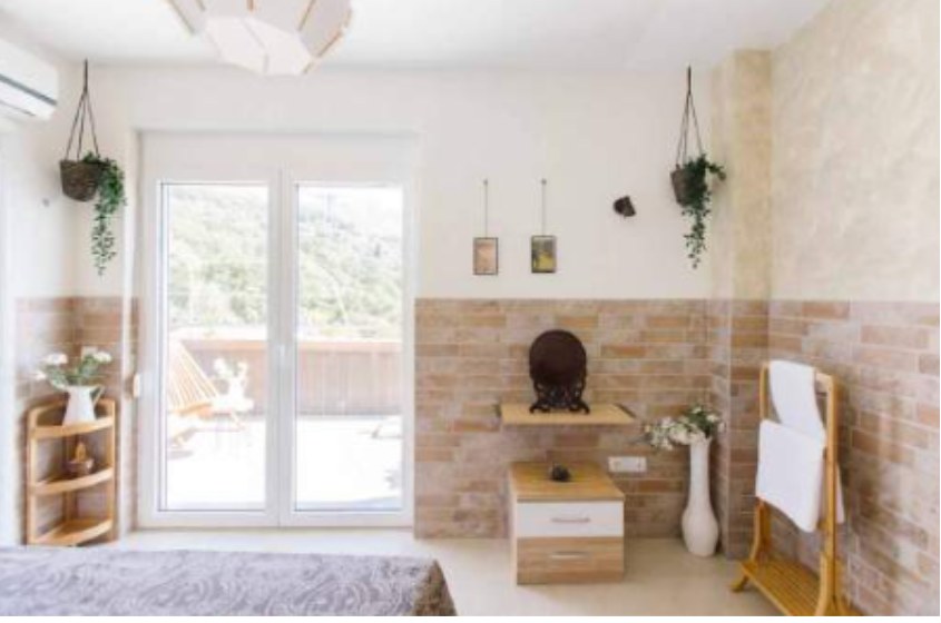 Mountainview ensuite bedroom with balcony doors and hanging plants