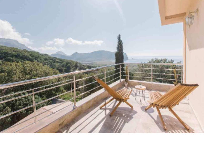 Private balcony with two wooden chairs overlooking the Adriatic coastline