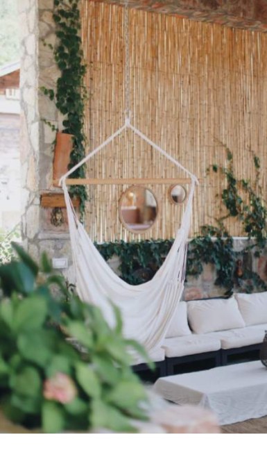 A hanging chair and daybed in a shaded corner of the retreat