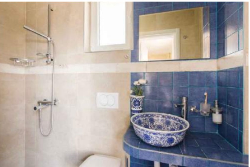 Ensuite bathroom with blue tiles and a hand-painted ceramic basin