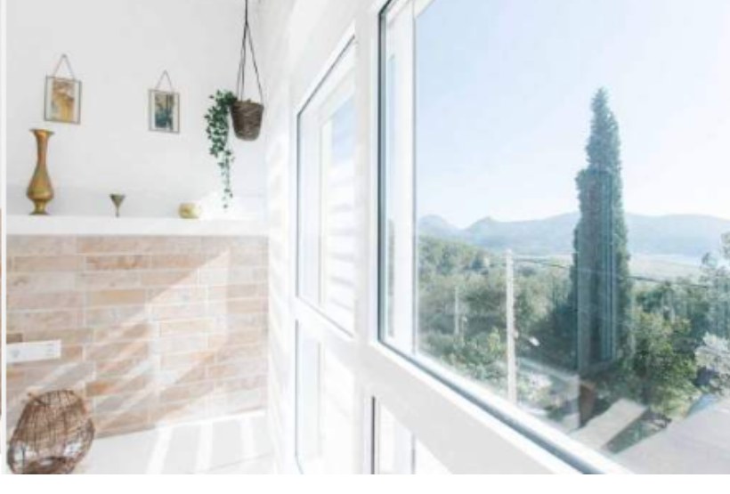 Suite window framing cypress trees and the mountains beyond