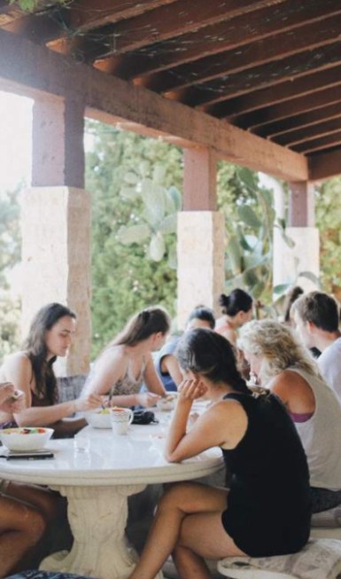 Guests sharing a plant-based meal at a long communal table