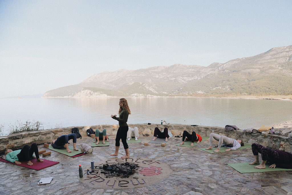 Retreat guests practicing yoga on the stone terrace above the Adriatic at Mahakala Center